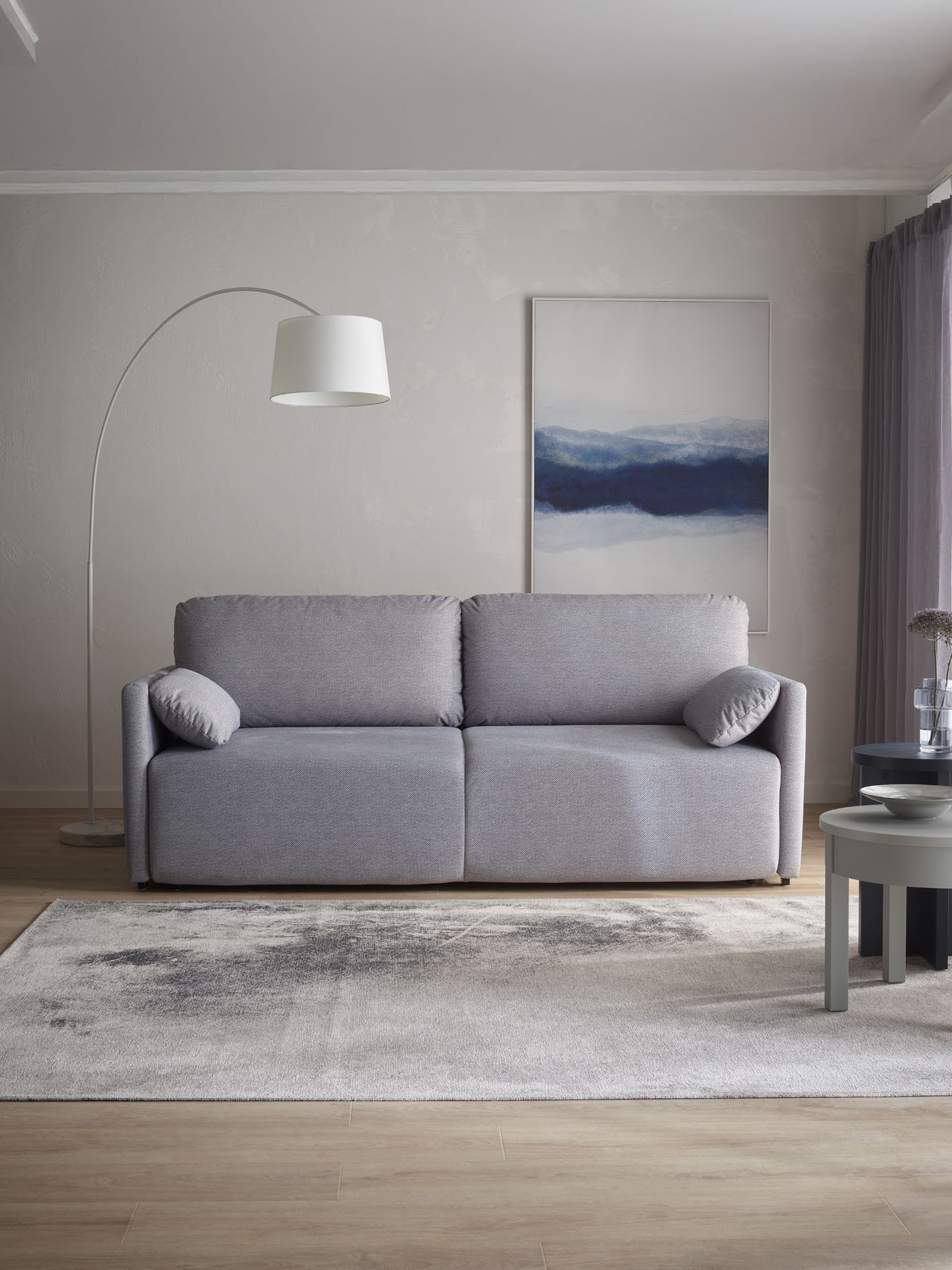 Szara sofa na beżowej ścianie