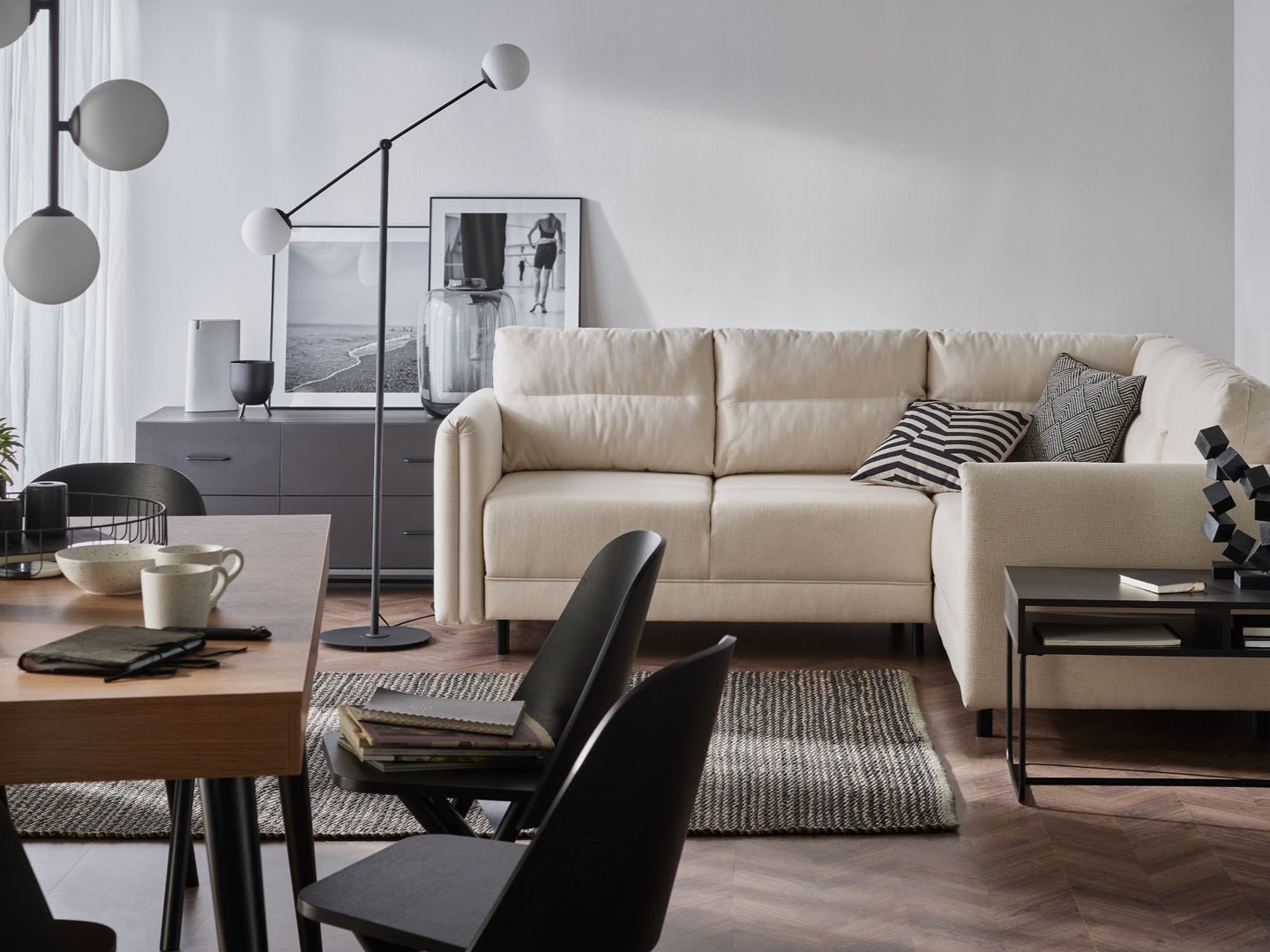 Sofa, dywan w salonie. Na pierwszym planie stół z krzesłami