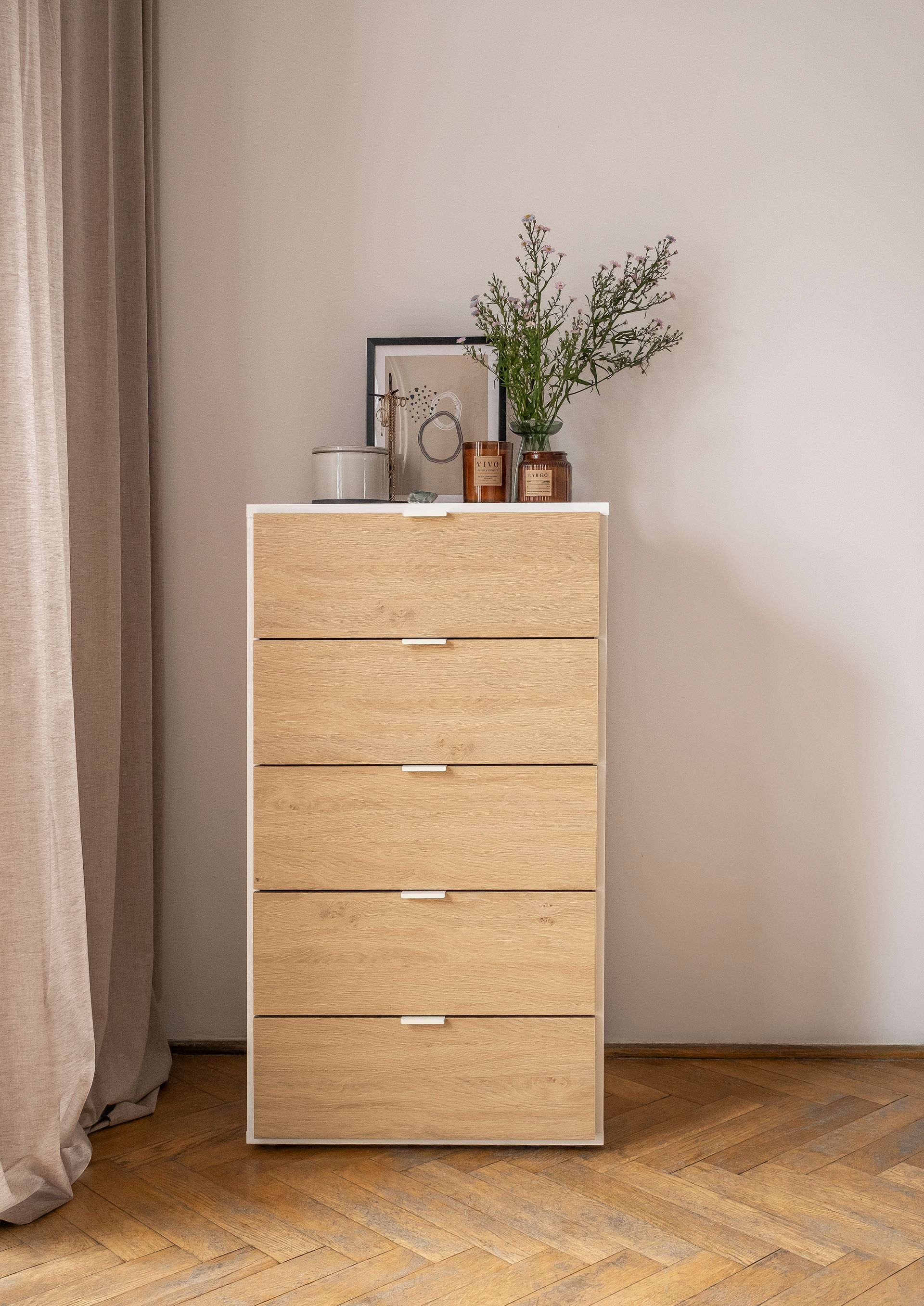Komoda z pięcioma szufladami w minimalistycznym wnętrzu.