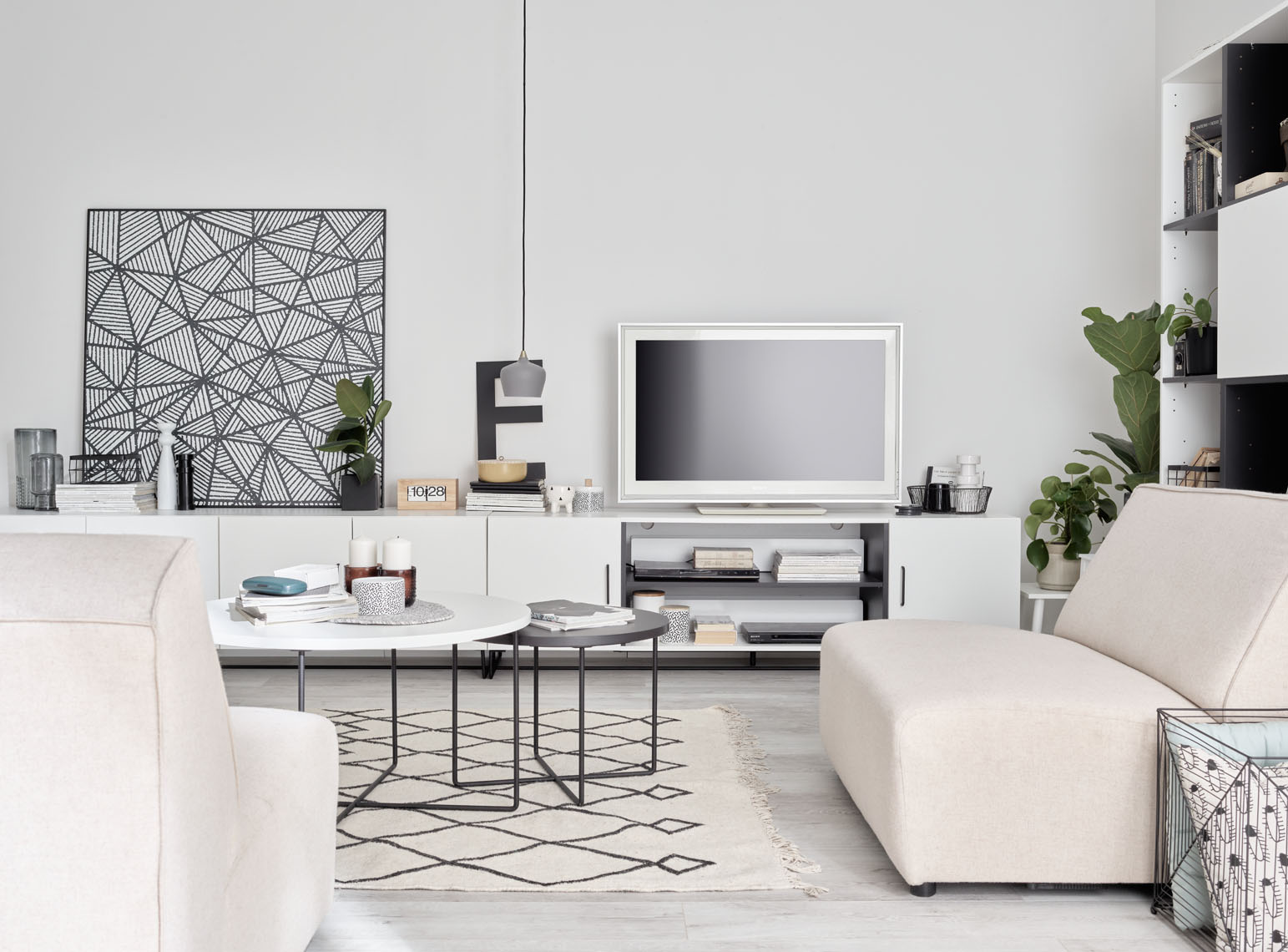 Salon w stylu minimalistycznym z białą sofą, geometrycznym dywanem i czarno-białymi dekoracjami