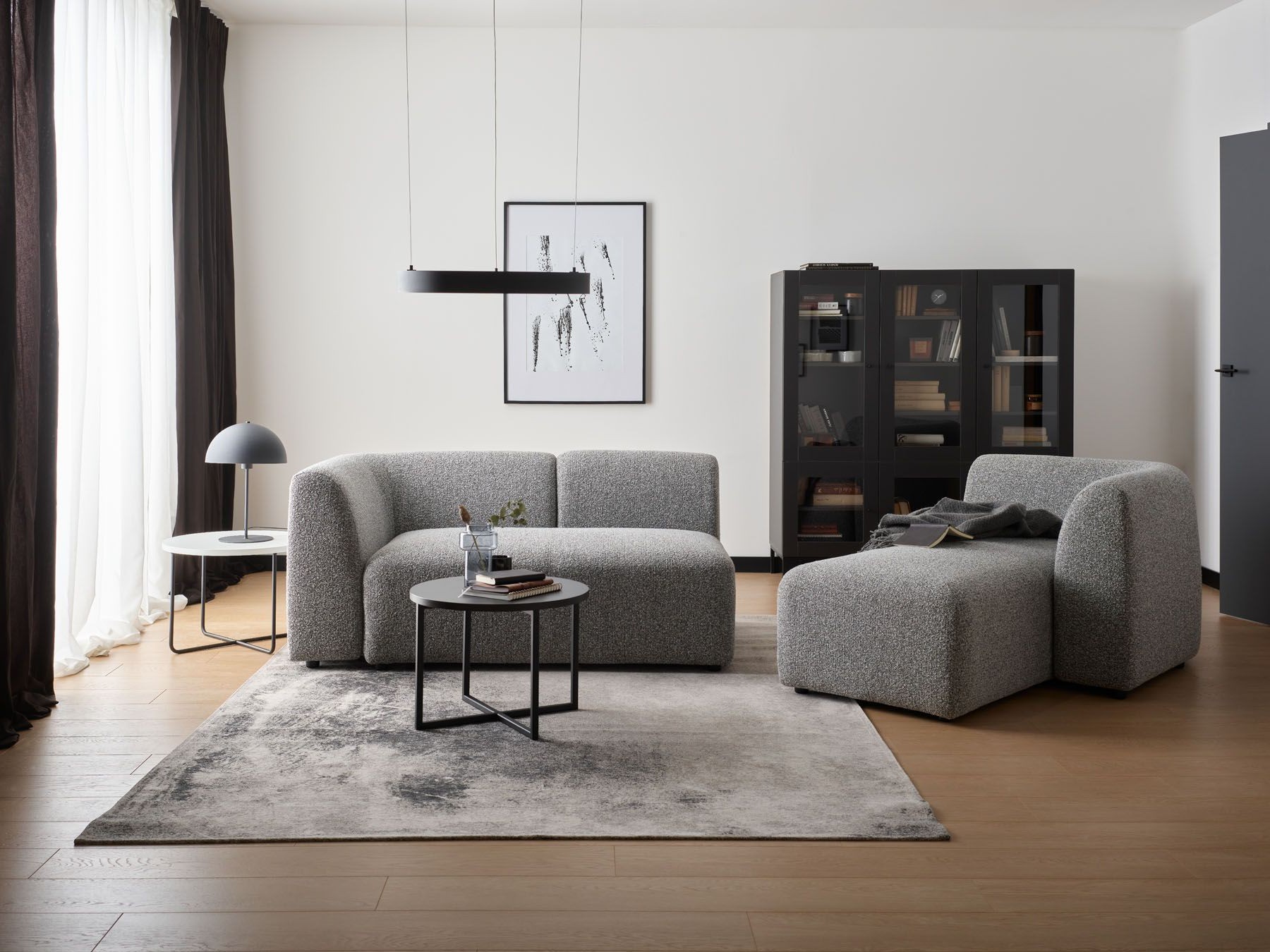 Nowoczesny salon z szarą tapicerką, czarnymi akcentami