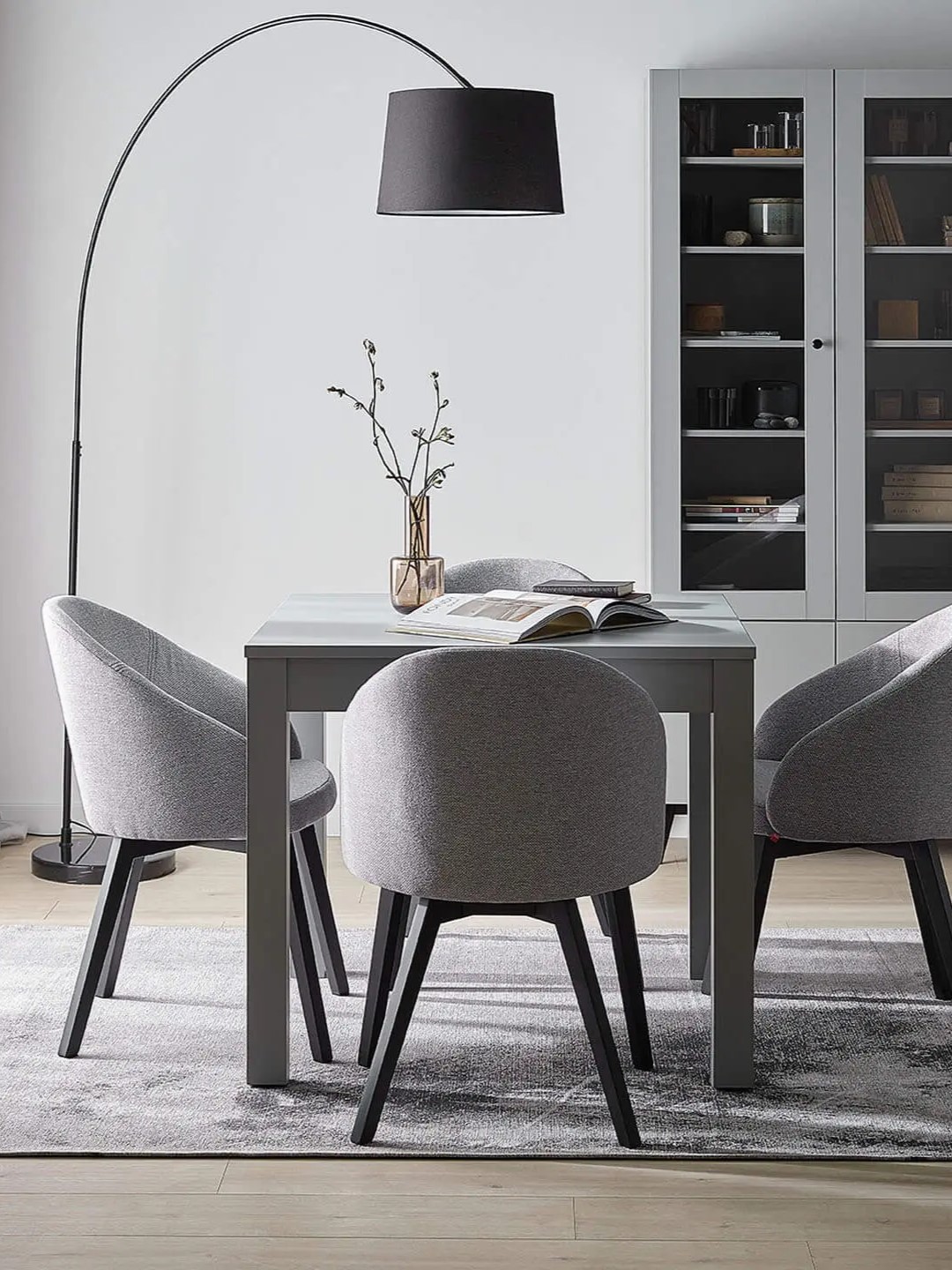 Lampa z dużym kloszem oświetlająca elegancką przestrzeń jadalnianą.