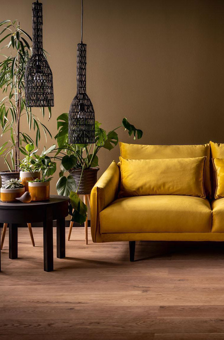 żółta sofa na tle brązowej ściany