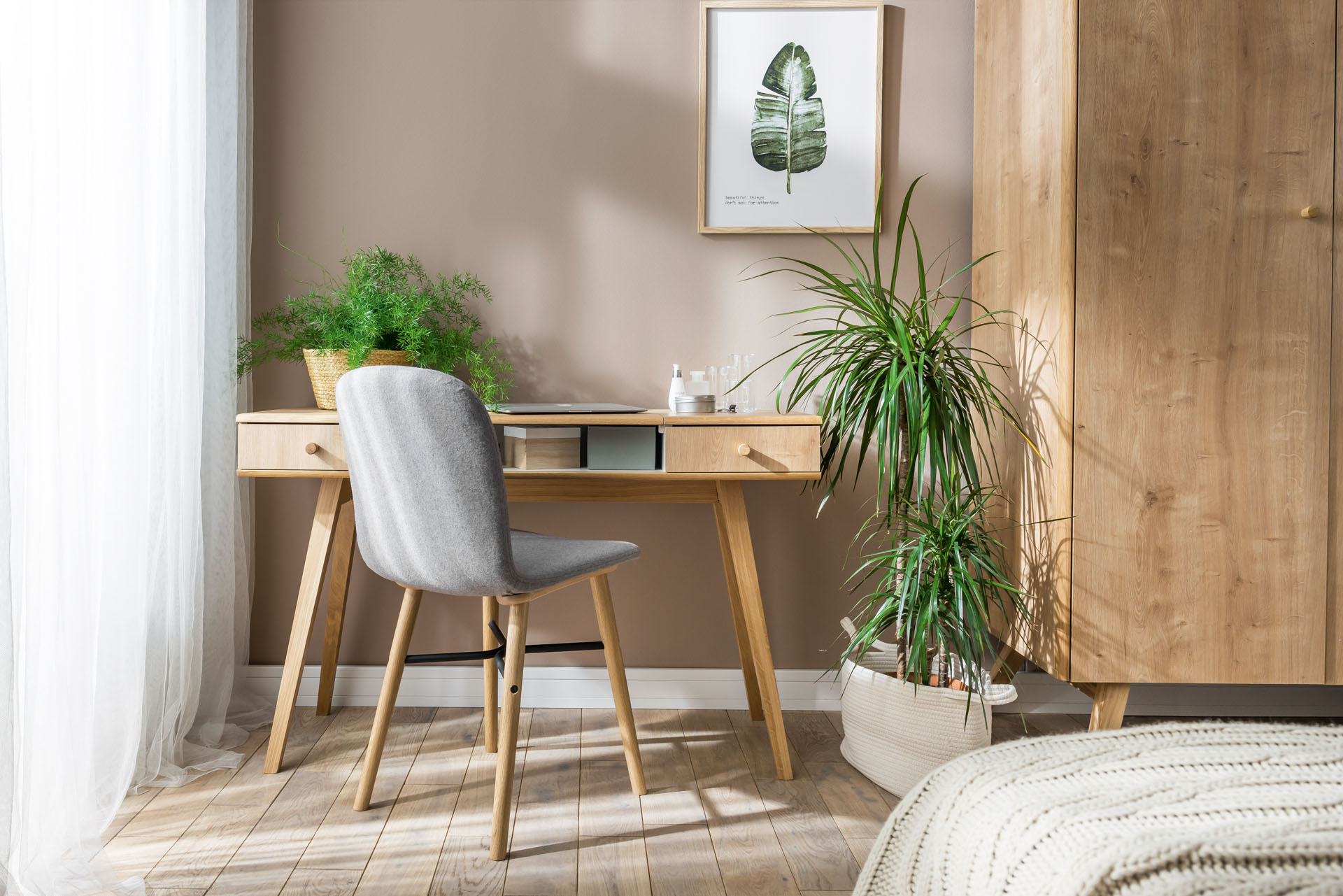 biurko z palmą w jasnym wnętrzu