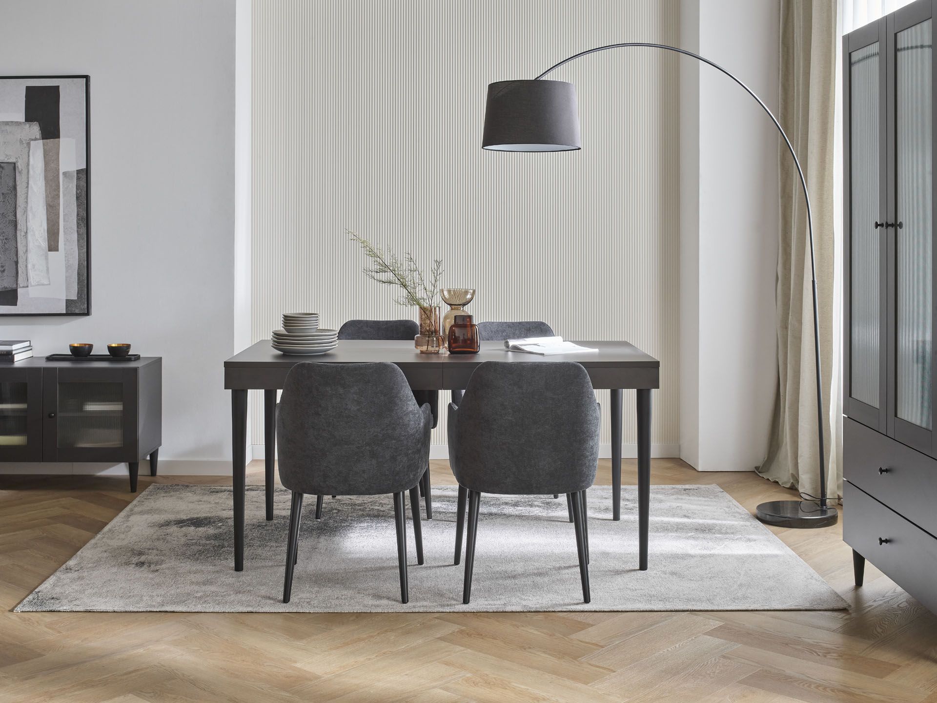 Nowoczesna jadalnia z czarnym stołem i tapicerowanymi krzesłami przy dużych oknach