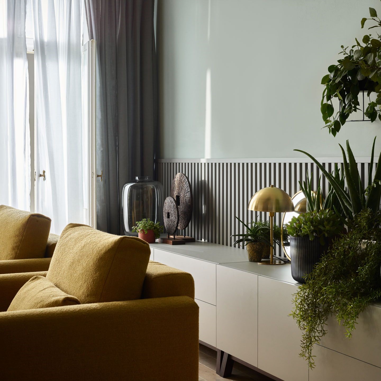 Salon z pistacjową ścianą i roślinami