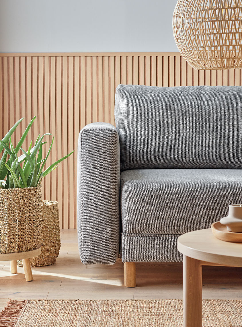szara sofa w salonie w barwach dębu