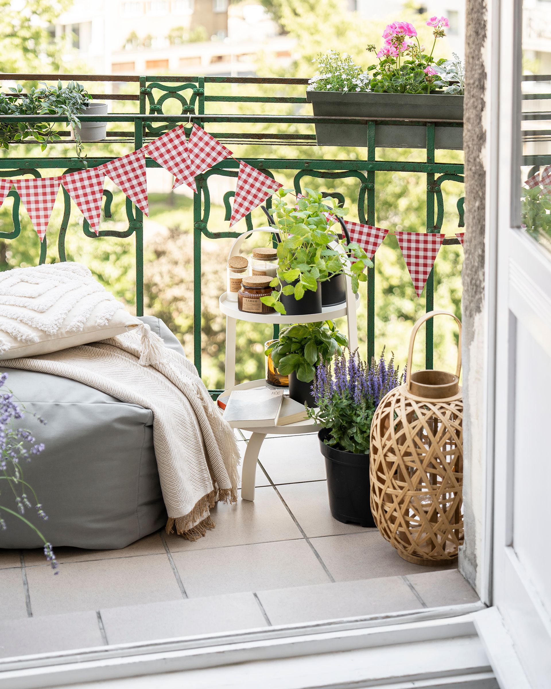 Balkon udekorowany girlandą, ziołami i kolorowymi kwiatami