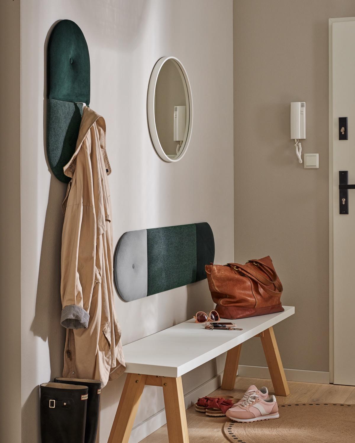 przedpokój z ławką, lustrem i eleganckim panelem ściennym