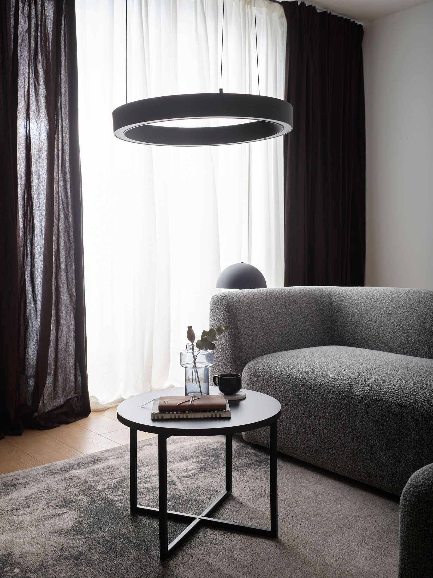 Neutralna barwa światła w salonie, szara sofa