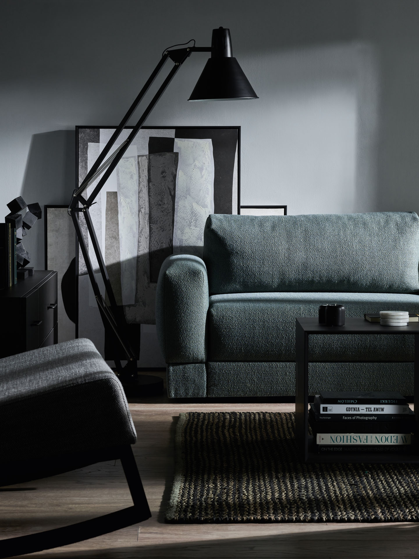 ciemnoniebieska sofa na tle szarej ściany