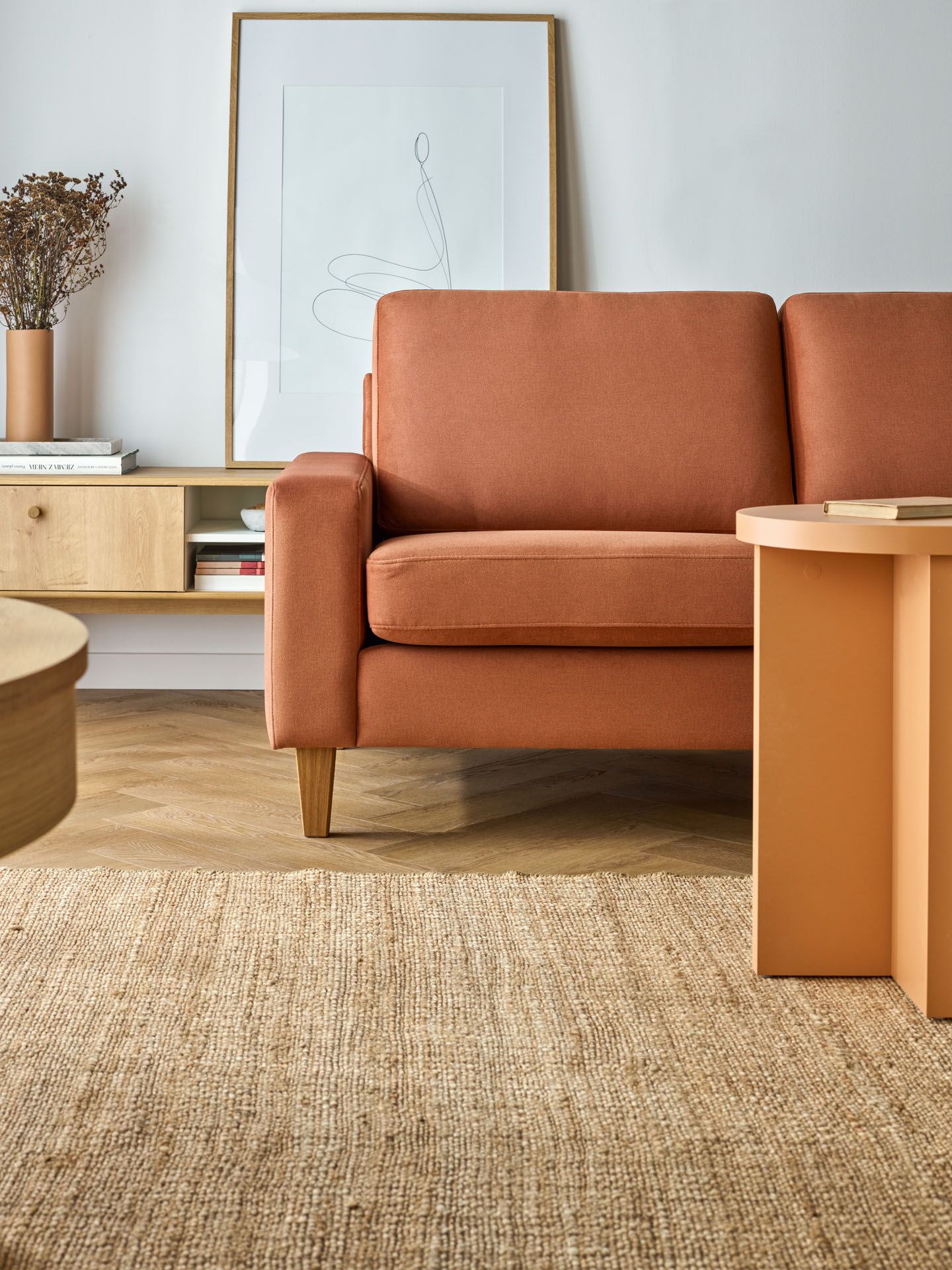 ruda sofa i pomarańczowy stolik kawowy
