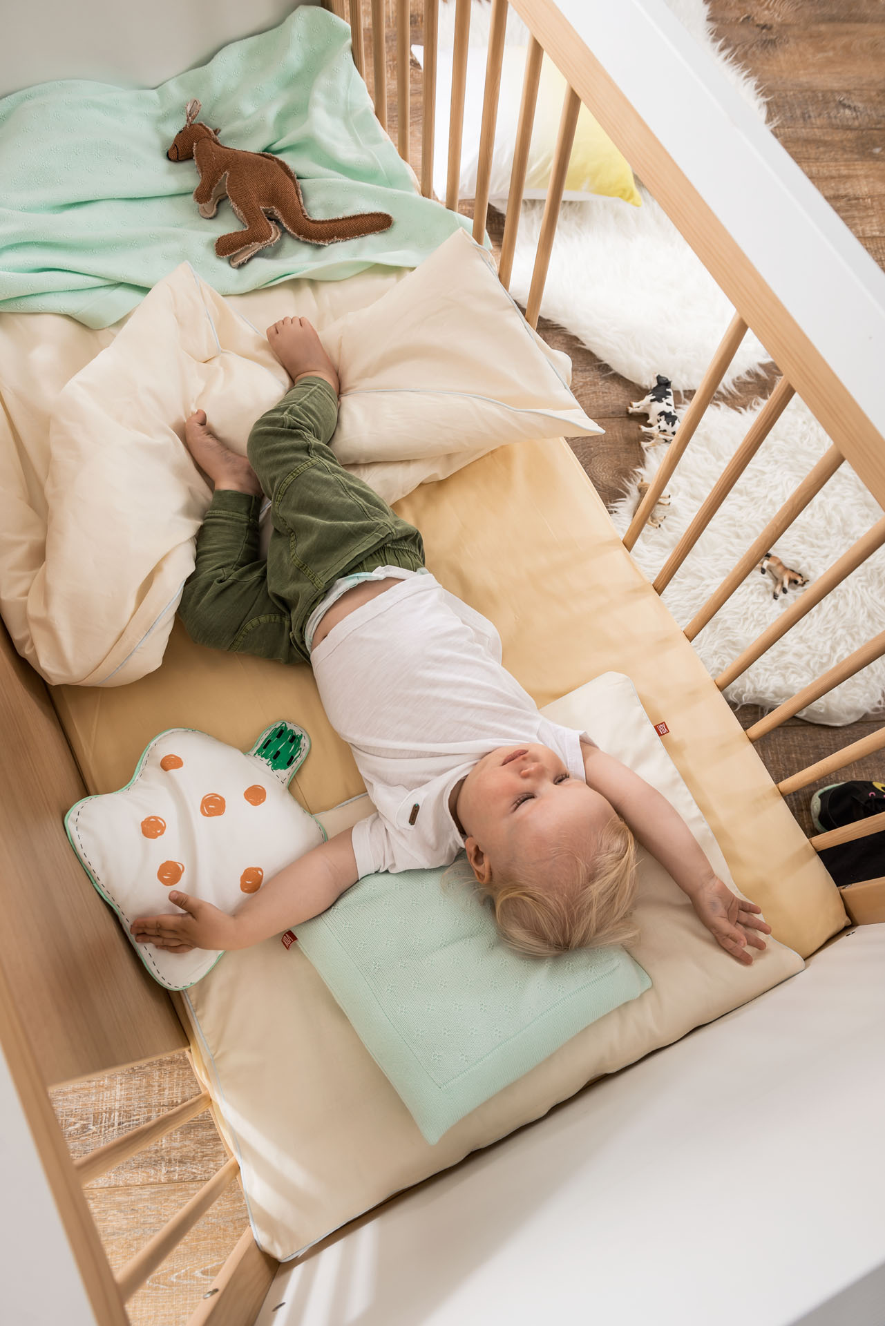 Małe dziecko leżące wygodnie na materacu w łóżeczku