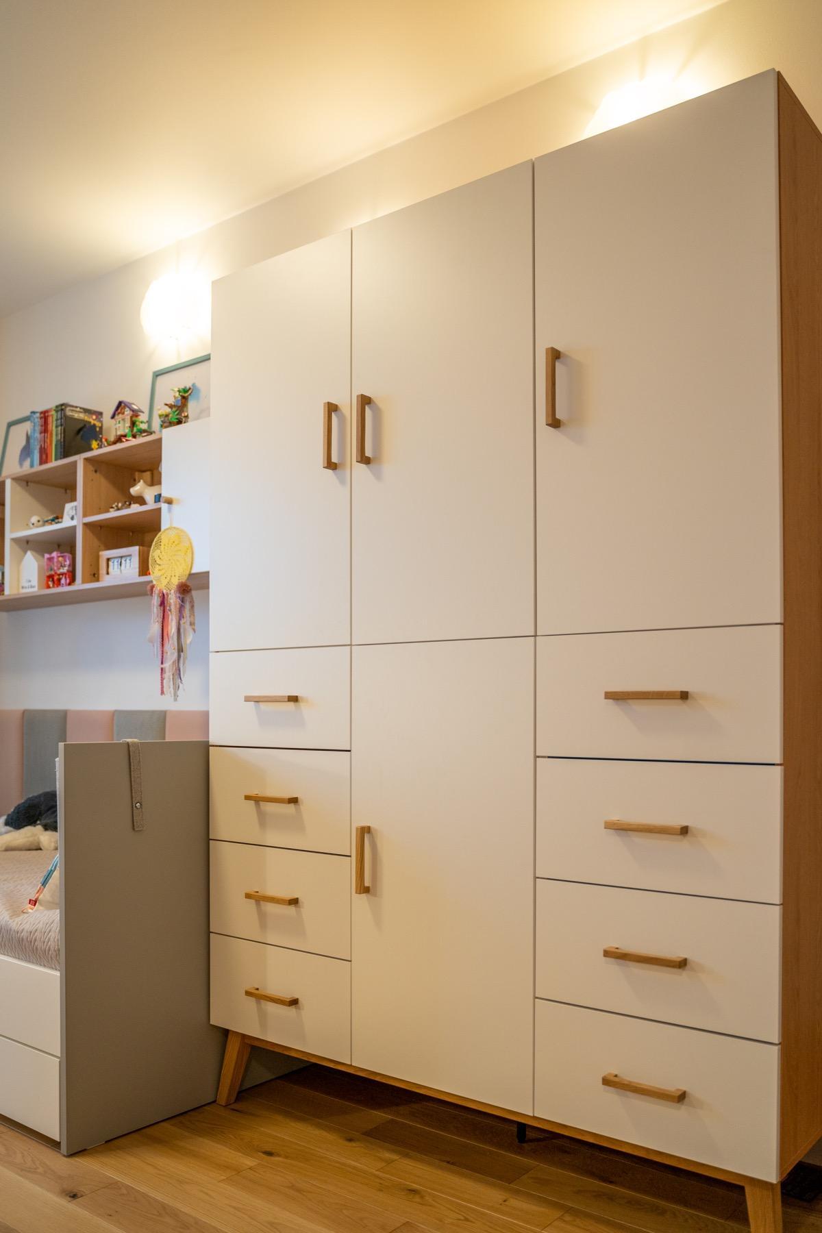 Pojemna, nowoczesna szafa dziecięca z drewnianymi uchwytami i minimalistycznym designem
