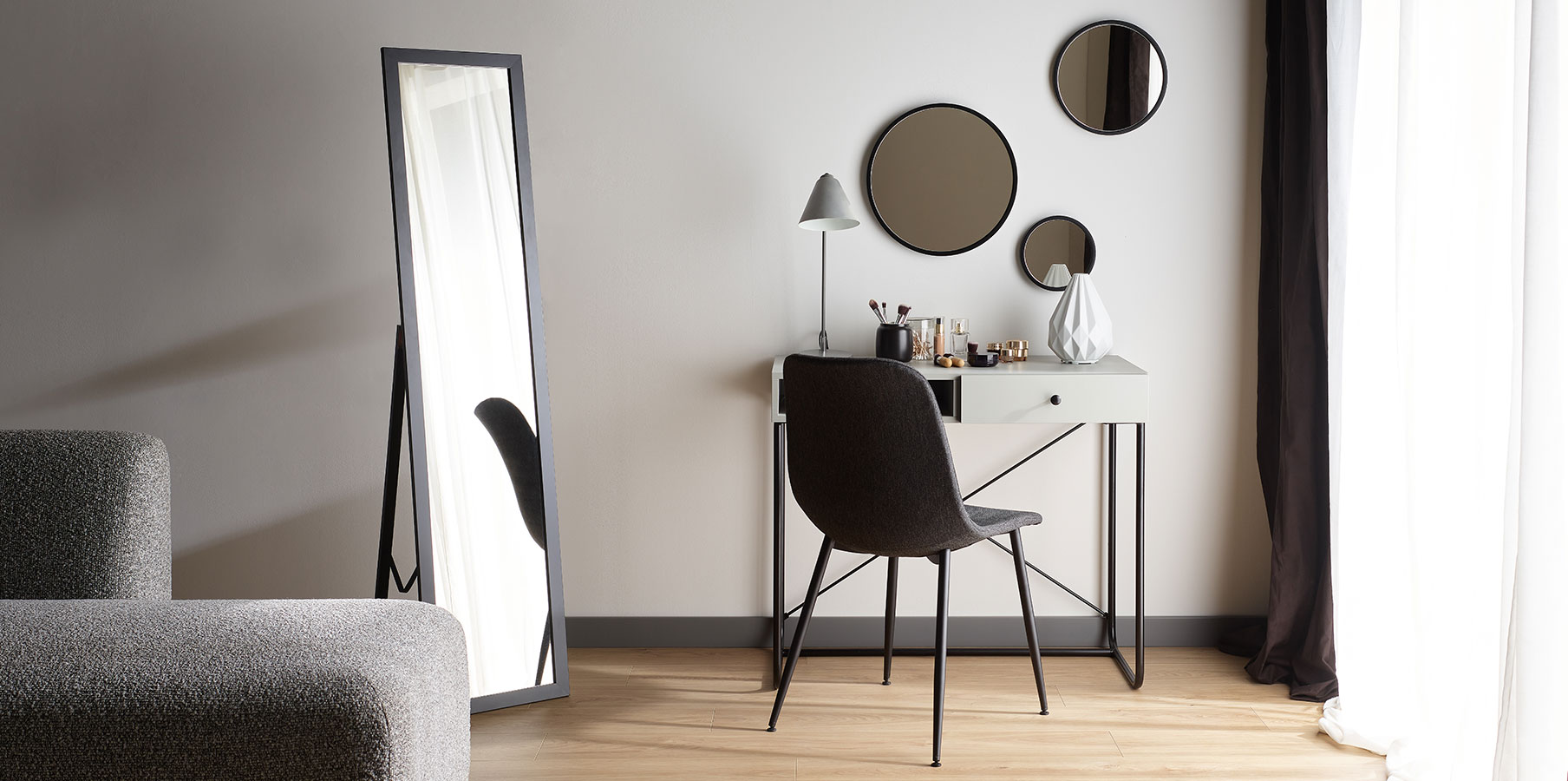 Minimalistyczna toaletka z okrągłymi lustrami i eleganckim krzesłem, tworząca stylową przestrzeń do codziennej pielęgnacji.