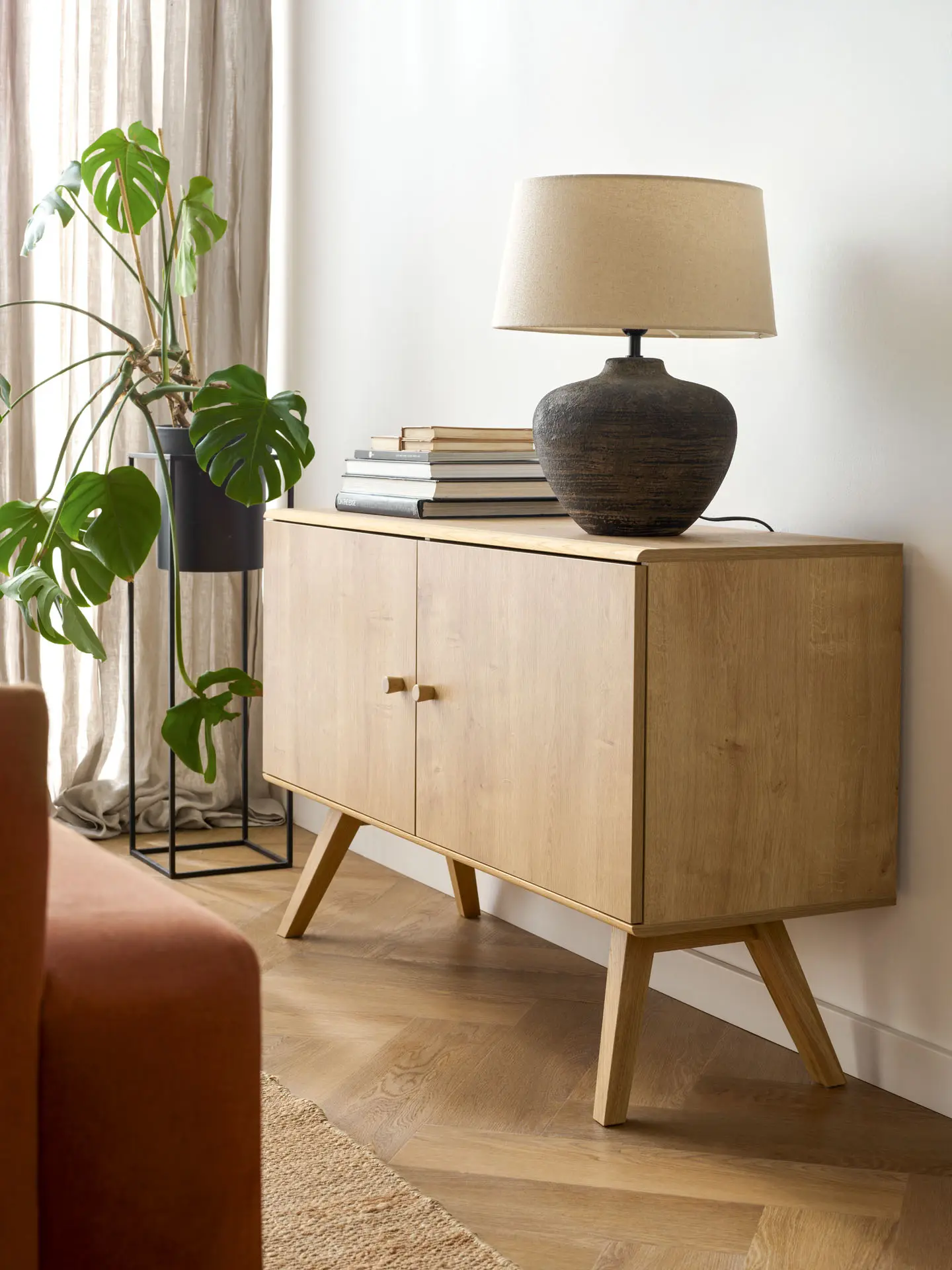 komoda drewniana z postarzaną ceramiczną lampą