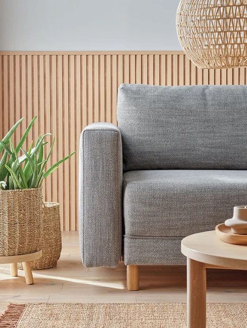 szara sofa w salonie w barwach dębu