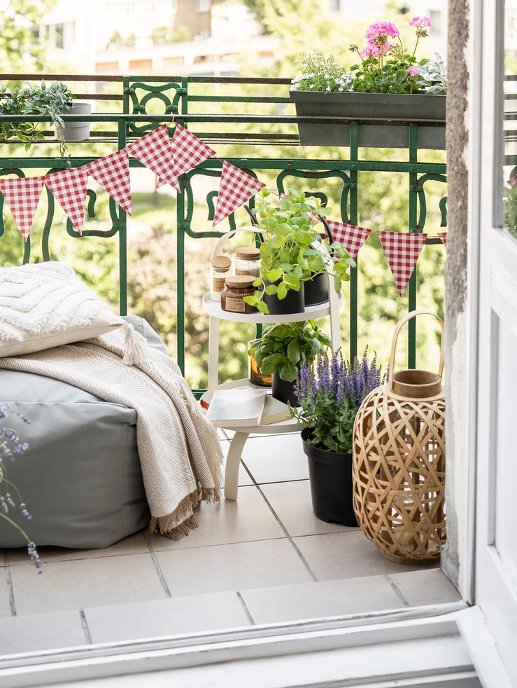 Balkon udekorowany girlandą, ziołami i kolorowymi kwiatami