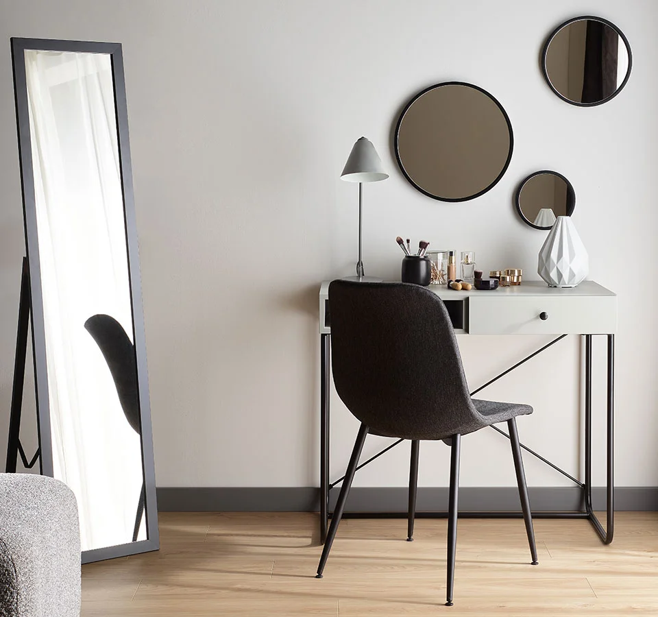 Minimalistyczna toaletka z okrągłymi lustrami i eleganckim krzesłem, tworząca stylową przestrzeń do codziennej pielęgnacji.